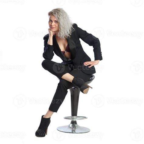 Woman With Blonde Curly Hair In Black Business Suit Sits On Chair Stock Photo At Vecteezy