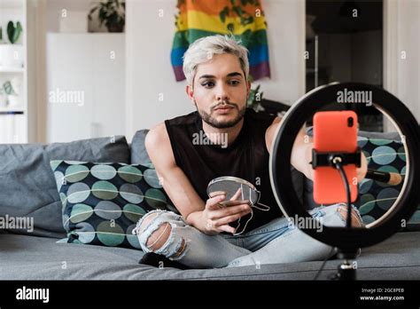 Gay man streaming en ligne maquillage vidéo tutorial avec téléphone mobile à l intérieur à la