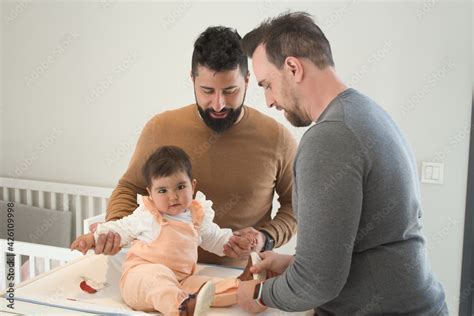 Gay Married Couple Changing Their Daughters Diaper In The Bedroom Stock Photo Adobe Stock