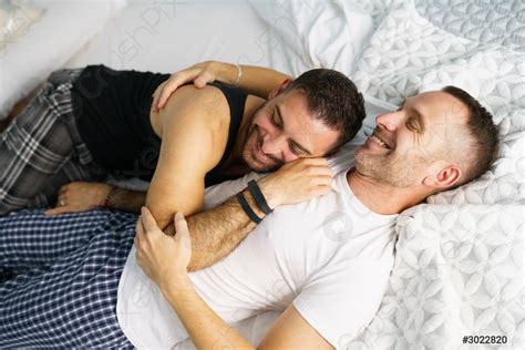 Gay Couple Hugging Together On Their Bed Stock Photo Crushpixel