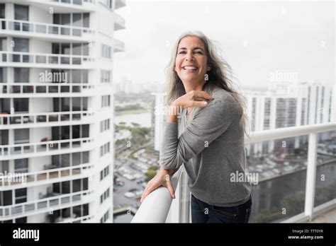 Portrait Of Happy Mature Woman Standing On Balcony Stock Photo Alamy