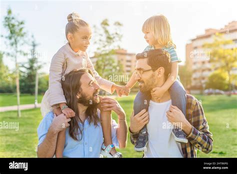 jeune gay couple de sexe masculin tenant sur leurs épaules leurs enfants Photo Stock Alamy