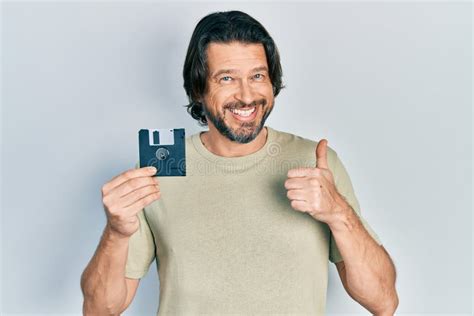 Mature Man With A Floppy Disk Holding His Index Finger Up Stock Image Image Of Holding Aged
