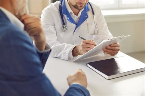 Mature Man Patient Visiting A Doctor At The Medical Office During Medical Examination Stock