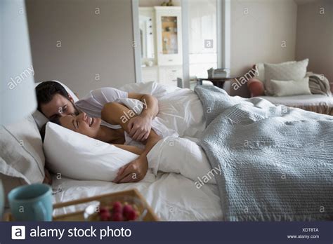 couple cuddling bed stock  couple cuddling bed stock images alamy