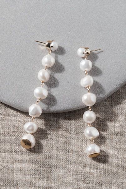 Two Pairs Of Earrings With Pearls Hanging From The End Of Each Earring