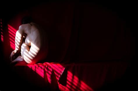 Premium Photo Naked Woman Sitting On Sofa In Darkroom