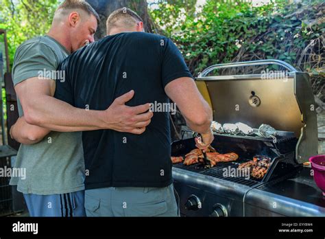 Gay Couple Grilling Food In Backyard Stock Photo Alamy