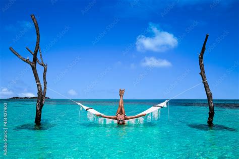 Elegant Sexy Woman In The White Bikini On The Sun Tanned Slim And Shapely Body Is Posing On