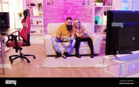 Bearded Boyfriend Playing Online Games With His Beautiful Blonde Girlfriend Sitting On Their