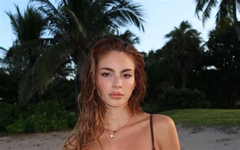 Agostina Goñi en bikini marrón posando en playa tropical ColorMusic