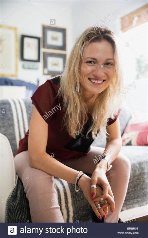 Portrait Smiling Blonde Woman Sitting On Sofa Stock Photo Alamy