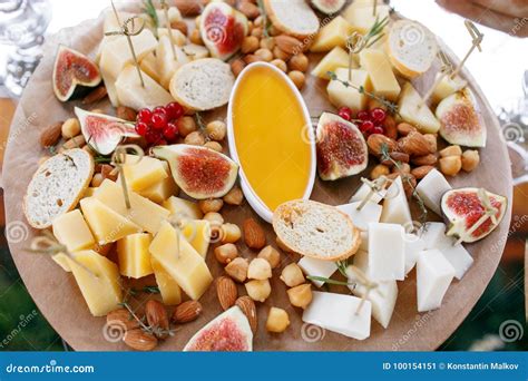 Assortment Of Cheese On Wooden Board Snacks On The Buffet Table Stock