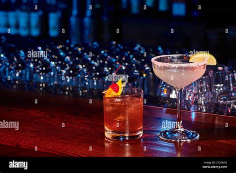 Sophisticated Alcohol Beverages Garnished With Lime And Cherry With Bar