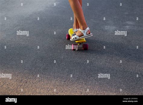 Defocus skater moving along asphalt road on a yellow skateboard wearing ...