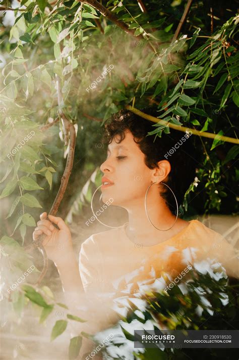 Portrait Of Sensual Brunette Woman With Short Hair Standing In Mist In Green Vegetation With