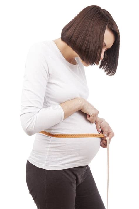 Shy Cute Pregnant Brunette Woman Posing With Measurement Tape In White Shirt While Taking