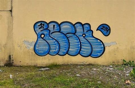 Graffiti On The Side Of A Building With Blue Spray Paint And Numbers