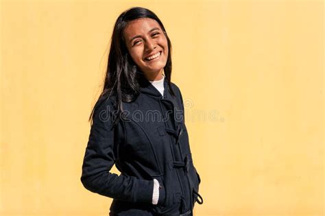 Retrato De Una Bella Joven Latina De Pelo Negro Y Ropa Casual Apoyada Sobre Un Fondo Amarillo