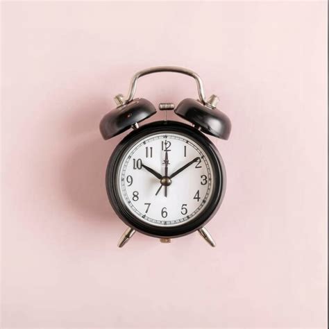 Premium Photo Pink Alarm Clock Lying On Pink Surface Background