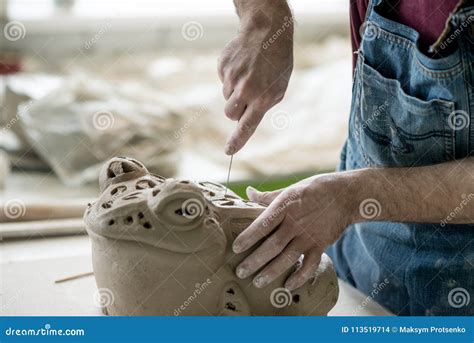 Ceramist Dressed In An Apron Sculpting Statue From Raw Clay In Bright