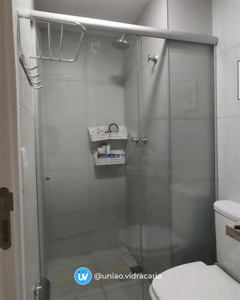 A White Toilet Sitting Next To A Walk In Shower Under A Bathroom Mirror