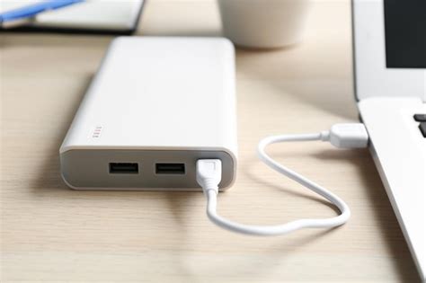 premium photo charging modern laptop  power bank  wooden table