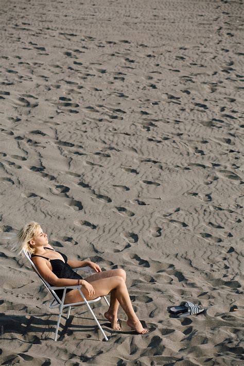 Blonde Woman Sunbathing On The Beach By Stocksy Contributor Boris Jovanovic Stocksy
