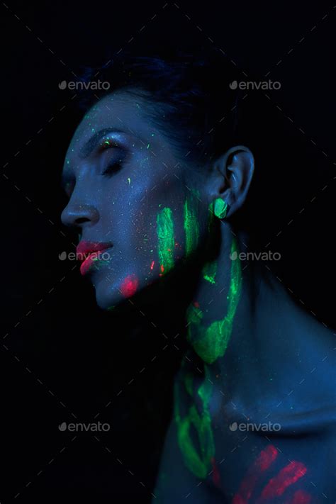 Sexy Nude Woman In Neon Light UV Paint On The Woman Face And Body Perfect Figure And Breasts