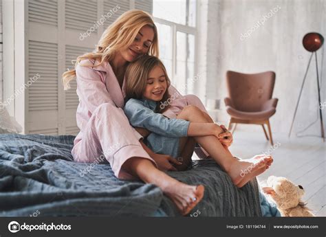 Beautiful Blonde Mother Embracing Her Daughter Smiling While Sitting Bed Stock Photo By