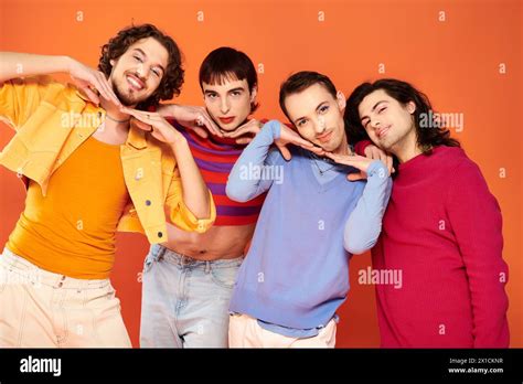 Cheerful Trendy Gay Men With Makeup In Vibrant Attires Posing Actively Together Pride Month