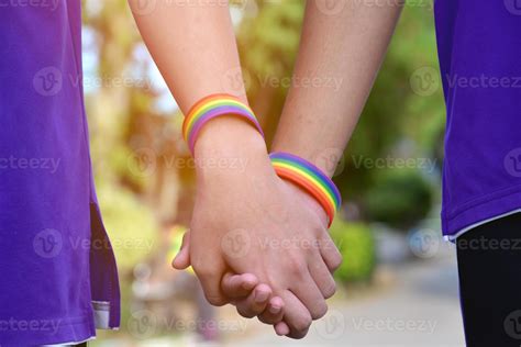 pulsera arcoíris que lleva en la mano un joven gay asiático para