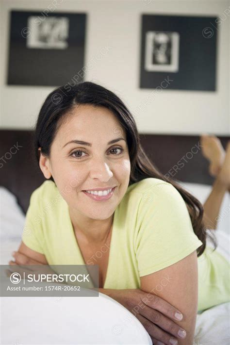 Portrait Of A Mature Woman Lying In The Bed And Smiling SuperStock