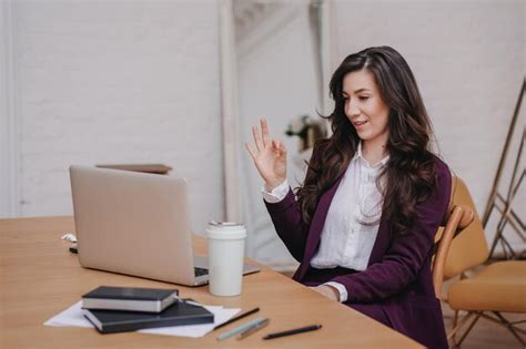 Premium Photo Satisfied Brunette Hispanic Woman In Violet Suit Sitting At Desk With Laptop And