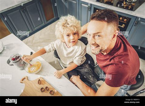Sticky Dough Top View Of Gay Innocent Boy Mixing Dough And Staring At Camera With Man Stock