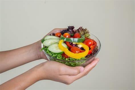 Free Photo Close Up Of Hands Holding A Bowl Of Salad
