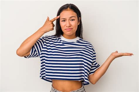 Mujer Latina Joven Aislada Sobre Fondo Blanco Sosteniendo Y Mostrando Un Producto En La Mano