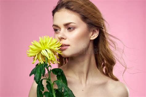Hermosa Chica Con Una Flor Amarilla En Un Fondo Rosa Nude Hombros Maquillaje Imagen De Archivo