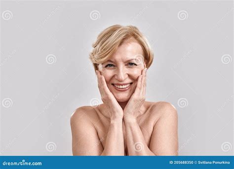 Portrait Of Beautiful Naked Middle Aged Woman Looking Excited Smiling At Camera Touching Her