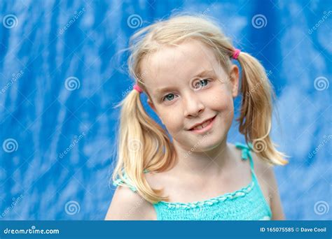 Jolie Jeune Fille Blonde Aux Pigeons Qui Se Met En Contact Avec Les Yeux Sur Fond Bleu Flou