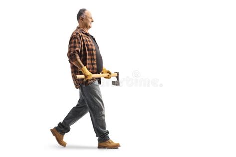 Full Length Profile Shot Of A Mature Man Walking And Holding An Axe
