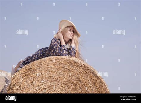 Une Jeune Fille Blonde Aux Cheveux Longs Dans Un Chapeau Blanc Se Repose Et Pose Pr S Des Gerbes