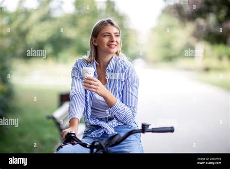 Blonde Woman In Public Park Relaxing On Bike Stock Photo Alamy
