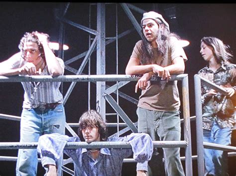 the group of people are on stage with their hands in their hair and one