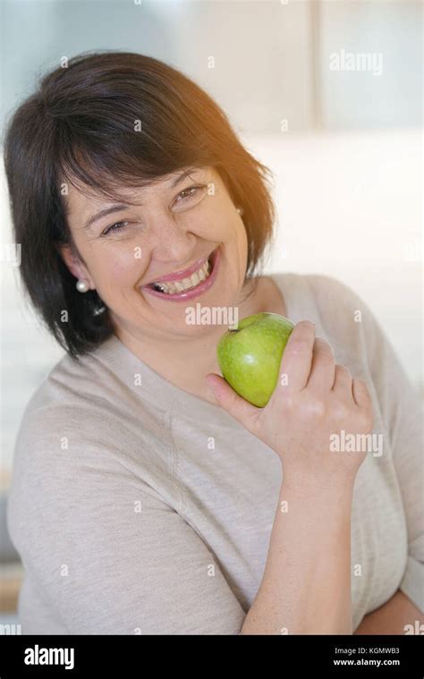 Cheerful Mature Woman Eating Green Apple Stock Photo Alamy