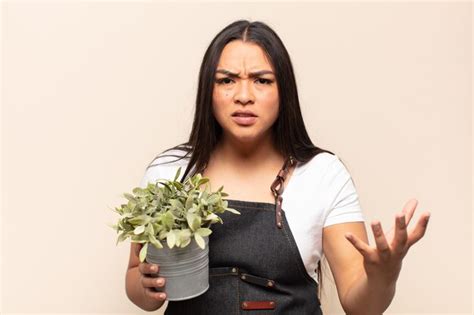 Mujer latina joven que parece enojada molesta y frustrada gritando wtf o qué te pasa Foto Premium