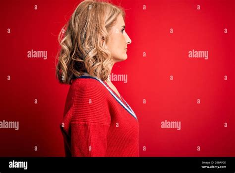 Middle Age Beautiful Blonde Woman Wearing Casual Sweater Over Isolated Red Background Looking To