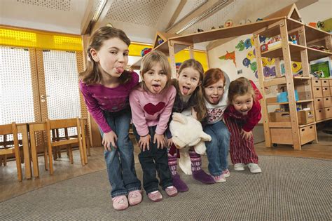 Germany, Children in nursery standing side by side, sticking out tongue