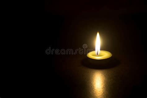 A Single Burning Candle Flame Or Light Glowing On A Spiral White Candle