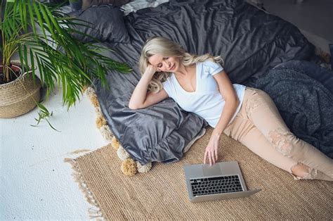 Premium Photo Blonde Woman Working On The Laptop In The Bedroom